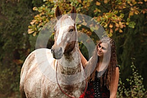 Amazing girl standing next to the appaloosa horse