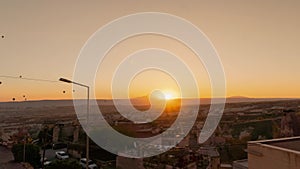 Amazing golden sunrise over mountain illuminating flying hot air balloons in Cappadocia in timelapse