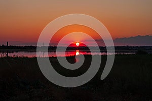 Amazing golden sunset on an empty beach. Orange and red shades on the sky. Wallpaper for desktop, sea travel poster