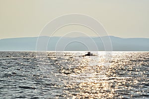 Amazing golden sunset reflection on the water at the sea with boat