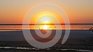 Amazing incredible red sunset with a huge round sun on a salt lake