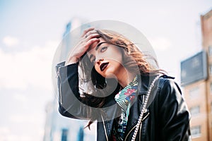 Amazing joyful pretty girl with long brunette hair. posing outdoor. leather jacket,brunette hair, bright red lips Close up fashion