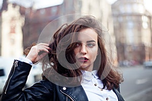 Amazing joyful pretty girl with long brunette hair. posing outdoor. leather jacket,brunette hair, bright red lips