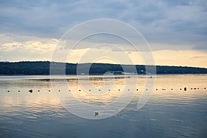 Amazing lake landscape in the evening. Blue yellow cloudy sky with reflection in water at sunset. Nature protection concept. Rural