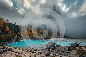 Amazing lake Sorapis and misty mountains at autumn, Dolomites, Italy