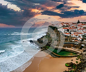 Amazing landscape of the Atlantic ocean shore in Azenhas do Mar village at sunset. View of of the sandy cove and dramatic cliffs.