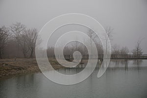 Amazing landscape of bridge reflect on surface water of lake, fog evaporate from pond make romantic scene or Beautiful bridge on l