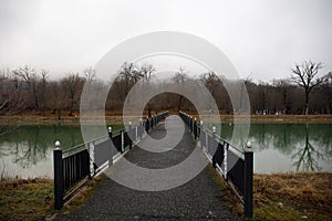 Amazing landscape of bridge reflect on surface water of lake, fog evaporate from pond make romantic scene or Beautiful bridge on l