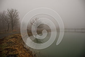 Amazing landscape of bridge reflect on surface water of lake, fog evaporate from pond make romantic scene or Beautiful bridge on l