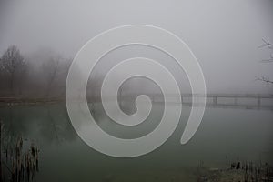 Amazing landscape of bridge reflect on surface water of lake, fog evaporate from pond make romantic scene or Beautiful bridge on l