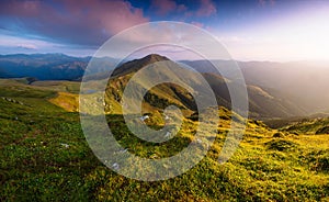 Amazing landscape in the mountains at sunrise. Colorful morning scene with first sunlight glowing hills and valleys.