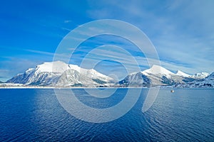 Amazing landscape of outdoor view of coastal scenes of huge mountain covered with snow on Hurtigruten voyage during a