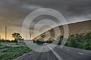 Amazing landscape of road among stone autumn mountains with bright blue soft cloudy blue sky or mountains stretching into the brig