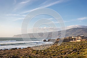 Amazing landscape scenario at the Guincho beach in Cascais, Portugal. Sunset colors, mountains, big waves.