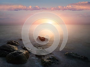 Amazing landscape of sunrise at sea. Colorful morning view of dramatic sky, seascape and rock. Long exposure image. Greece. Medite