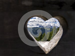 Amazing  landscape to the Marmolada and its glaciers through a wooden heart. Marmolada is the highest mountain of the Dolomites