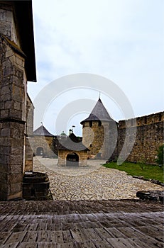 Amazing landscape view of courtyard with ancient stone buildings in the medieval castle. High stone wall with tower