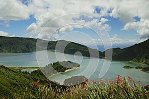 amazing landscape view of crater volcano lake in Sao Miguel island of Azores Portugal with flowers beautiful turquoise water