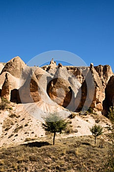 Amazing landscape view of typical geologic formations of Cappadocia. Mountain in the sunset light in the background