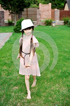 Amazing little girl in pink dress and white hat