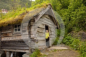 Amazing little wooden small house next to a waterfall on the dock of Hellesylt, child playing in the house