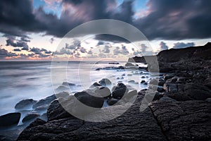 Sea sunrise at rocky beach