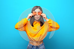 amazing looking mixed races woman with funny face covering her eyes with valentines red hearts giving a kiss