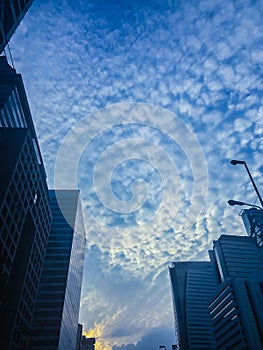 Amazing mammatus clouds over Bangkok, Thailand, with tall buildings foreground.