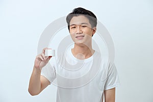 Amazing man advising recommendation buy, holding facial cream isolated grey background