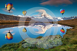 Amazing Matterhorn peak and hot air balloons reflecting in water