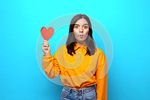 amazing mixed races woman with funny face holding up big heart-shaped valentine