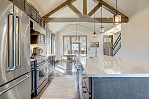 Amazing modern and rustic luxury kitchen with vaulted ceiling and wooden beams, long island with white quarts countertop