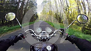 Amazing motorcycle riding towards morning sun on the beautiful forested road. Classic cruiser/chopper forever!