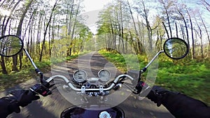 Amazing motorcycle riding towards morning sun on the beautiful forested road. Classic cruiser/chopper forever!