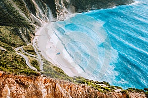 Amazing Myrtos beach with rolling waves. Beautiful coastline, cliffs surrounded the sea bay of blue water, Kefalonia