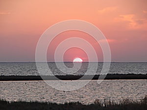 Amazing natural pictures of the sunset over the water mirror of the salt lake Sivash.