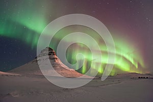 The amazing northern lights over the Kirkjufell in winter Iceland.