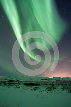 The amazing northern lights over the landscape in winter Iceland.