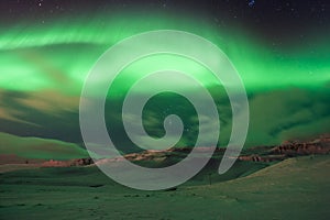 The amazing northern lights over the landscape in winter Iceland.