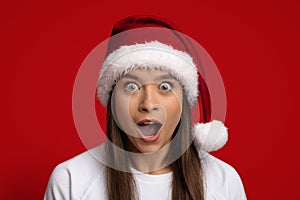 Amazing Offer. Portrait Of Shocked Woman Wearing Santa Hat Looking At Camera