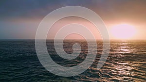 Amazing orange coastal sunset over ocean waves aerial. Sea reflecting sundown