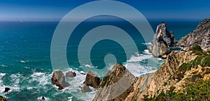 Amazing panorama of Rocky shore  Atlantic Ocean. View of high cliffs, foamy waves and sandy beach. Sunny summer seascape. Portugue photo