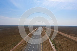 amazing panorama of the steppe and a straight line of the highway through the sandy desert in the Astrakhan region in