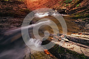 Amazing panoramic landscape mountain river in autumn forest at sunlight. View of stone water rapids and small waterfall.