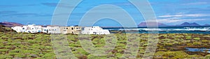 Amazing panoramic view of Orzola village on Lanzarote island with La Graciosa island on the background