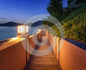 Amazing path with street lights on sea coast at night in summer