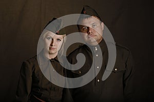 Amazing portrait young blonde woman and man in military uniform from second world war stand side by side