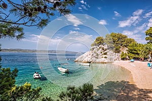 Amazing Punta Rata beach with boats against azure sea in Brela, Makarska, Dalmatia, Croatian azure coast photo