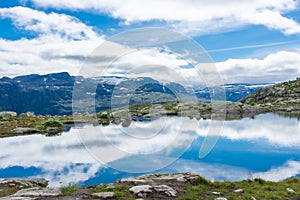 Amazing reflection over a lake in the mountains of Trolltunga hike,  Norway