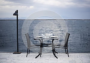 Amazing romantic dinner on the beach. Romance and love, dinning table setup with sea view in cloudy day